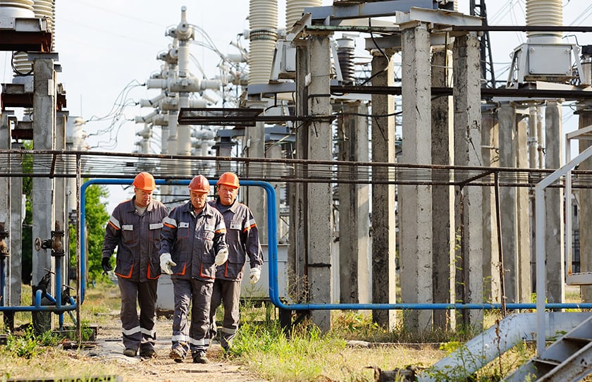 Energy workers in uniform walking through worksite