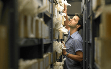 Man not finding his information in a hall full of files 