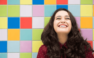 Woman in front of a colorful tile wall