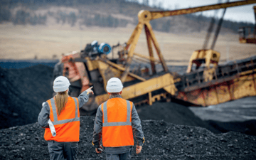 Coal maintenance workers looks over equipment in the field 