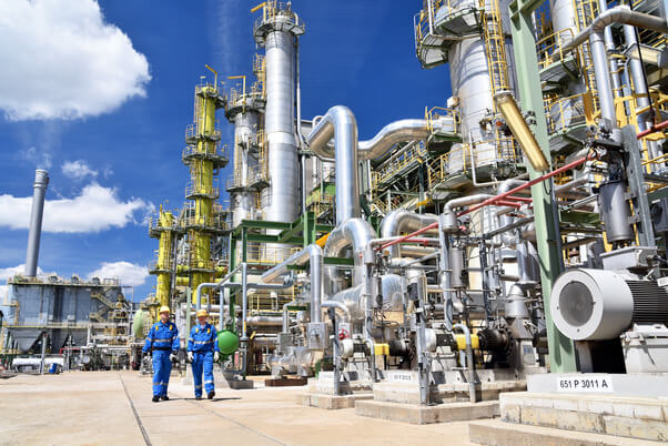 Two maintenance project managers walking in outdoor manufacturing site