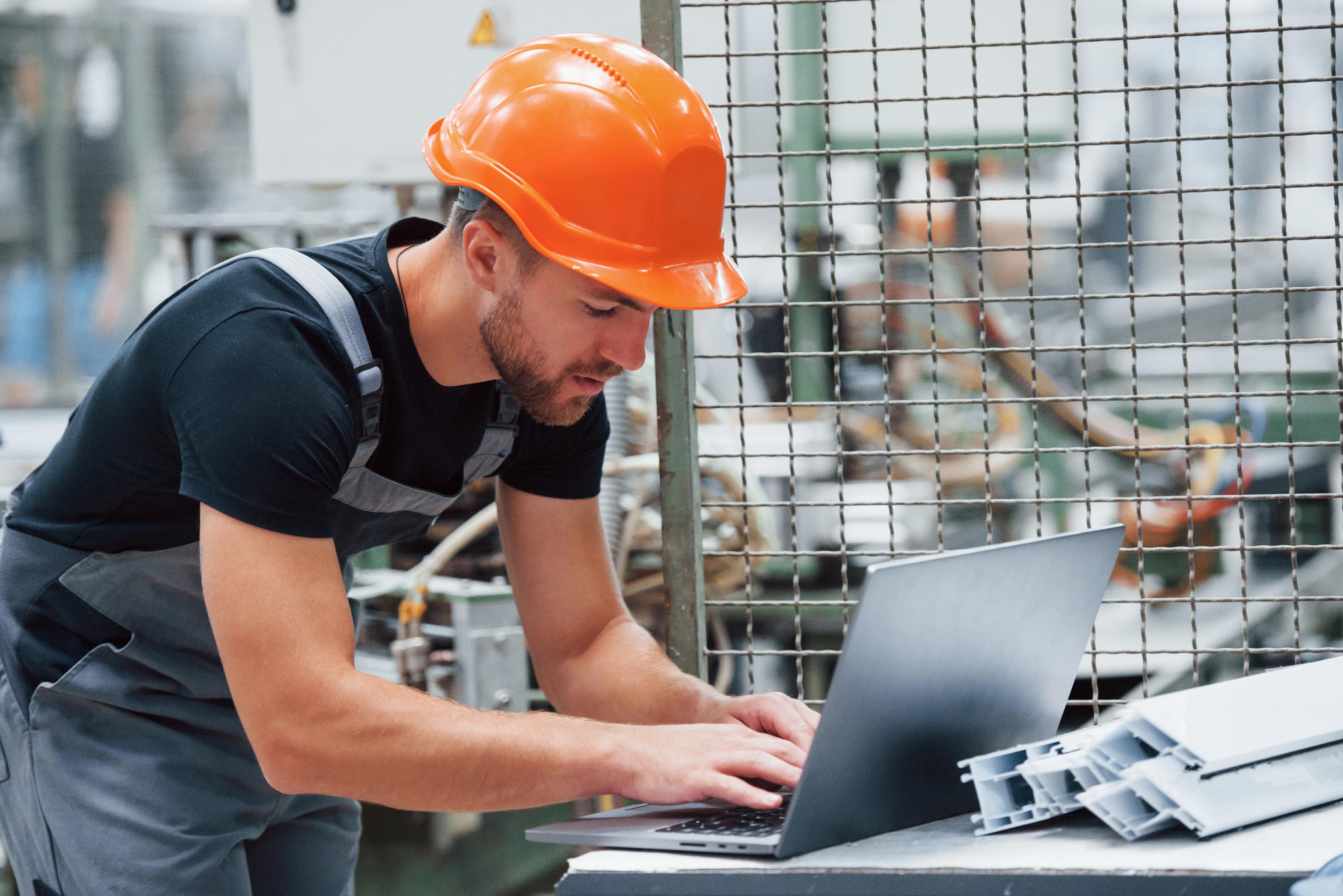 Maintenance technician documenting work on a latop