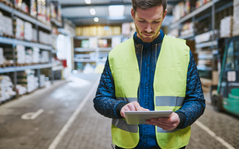 Technician checking warehouse inventory data on a mobile device