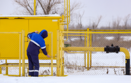 Worker opening gate to access machine in the snow