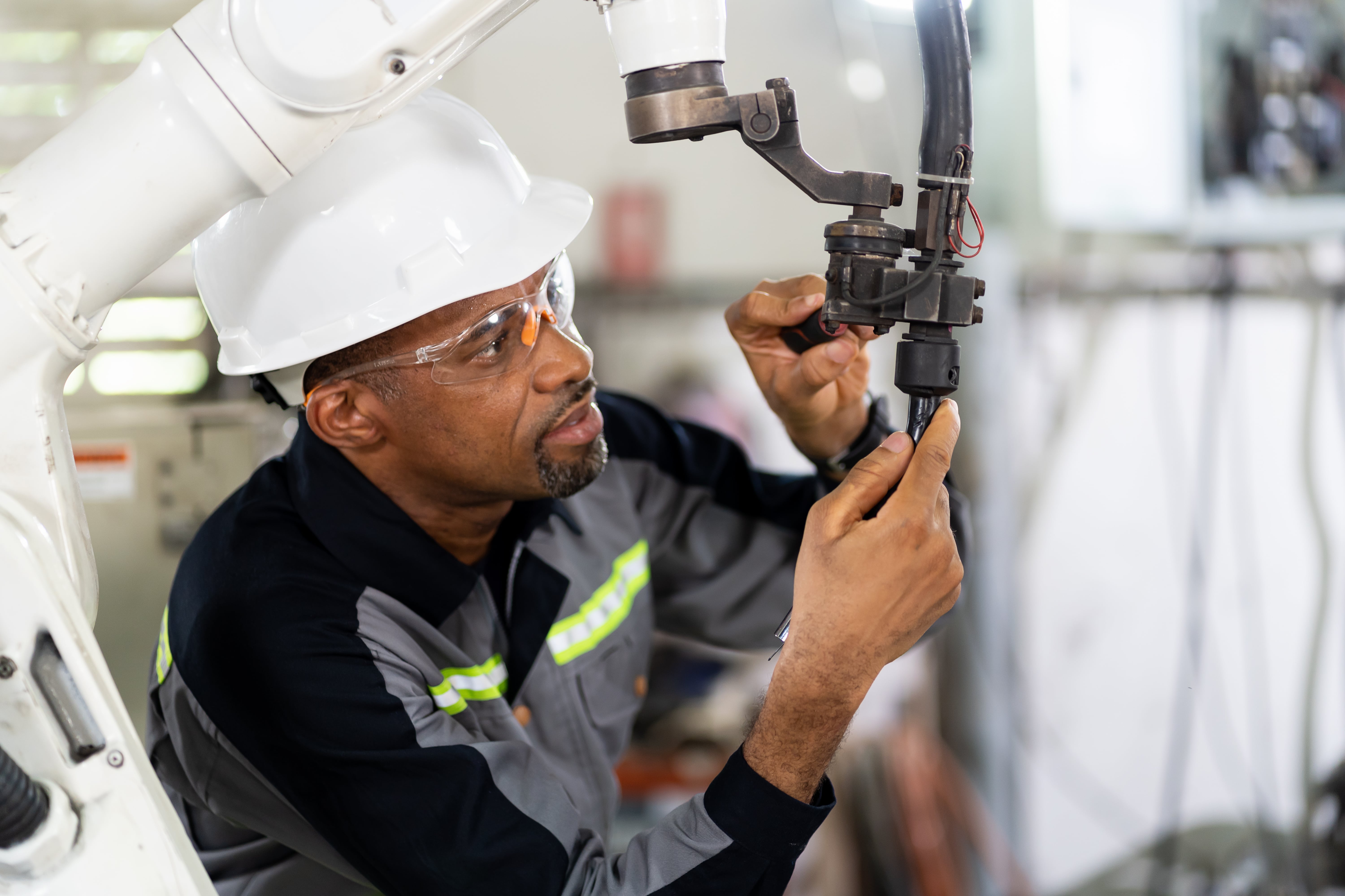 Maintenance technician adjusting arm of a machine