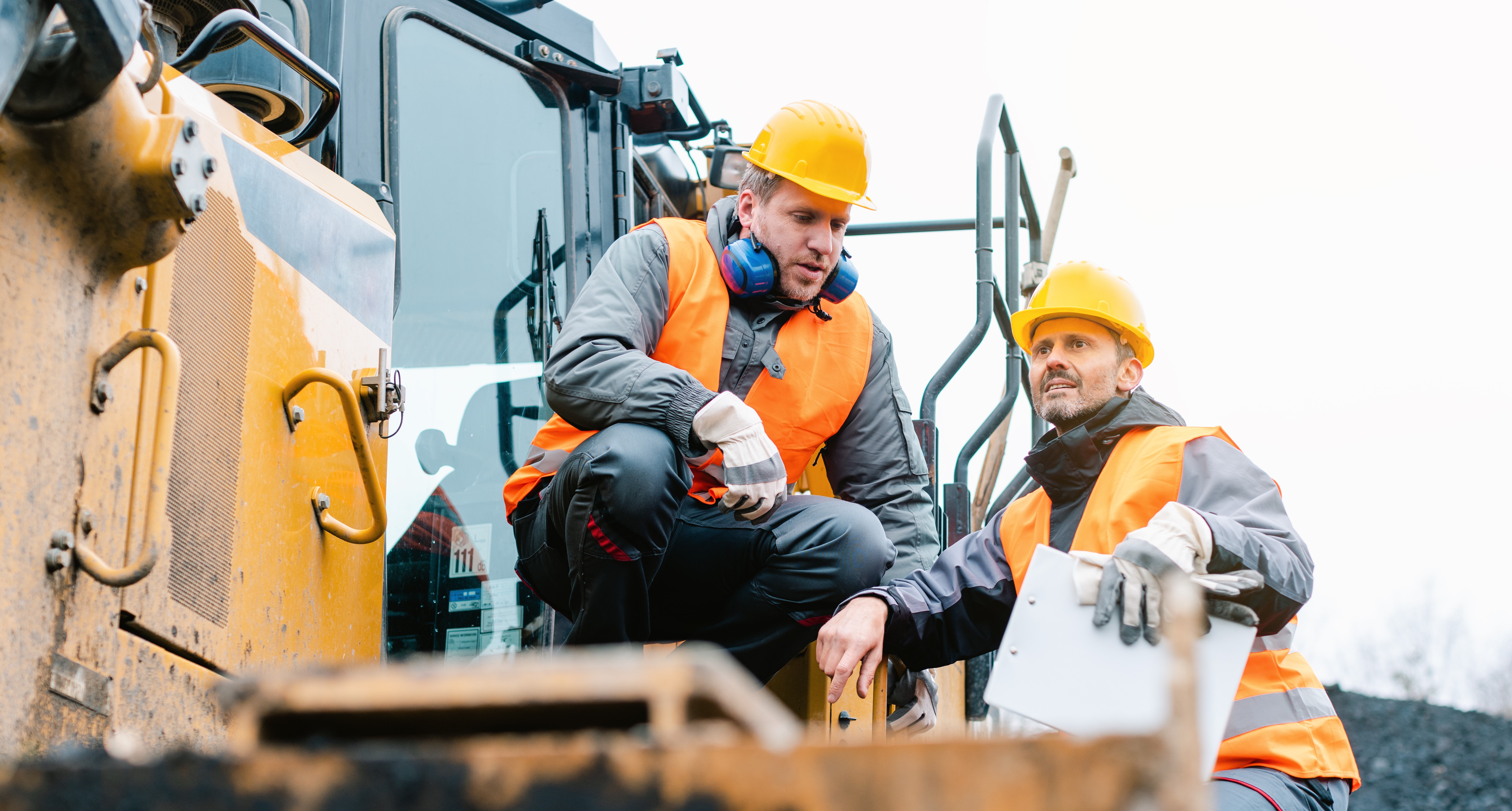 Maintenance workers on top of construction machine