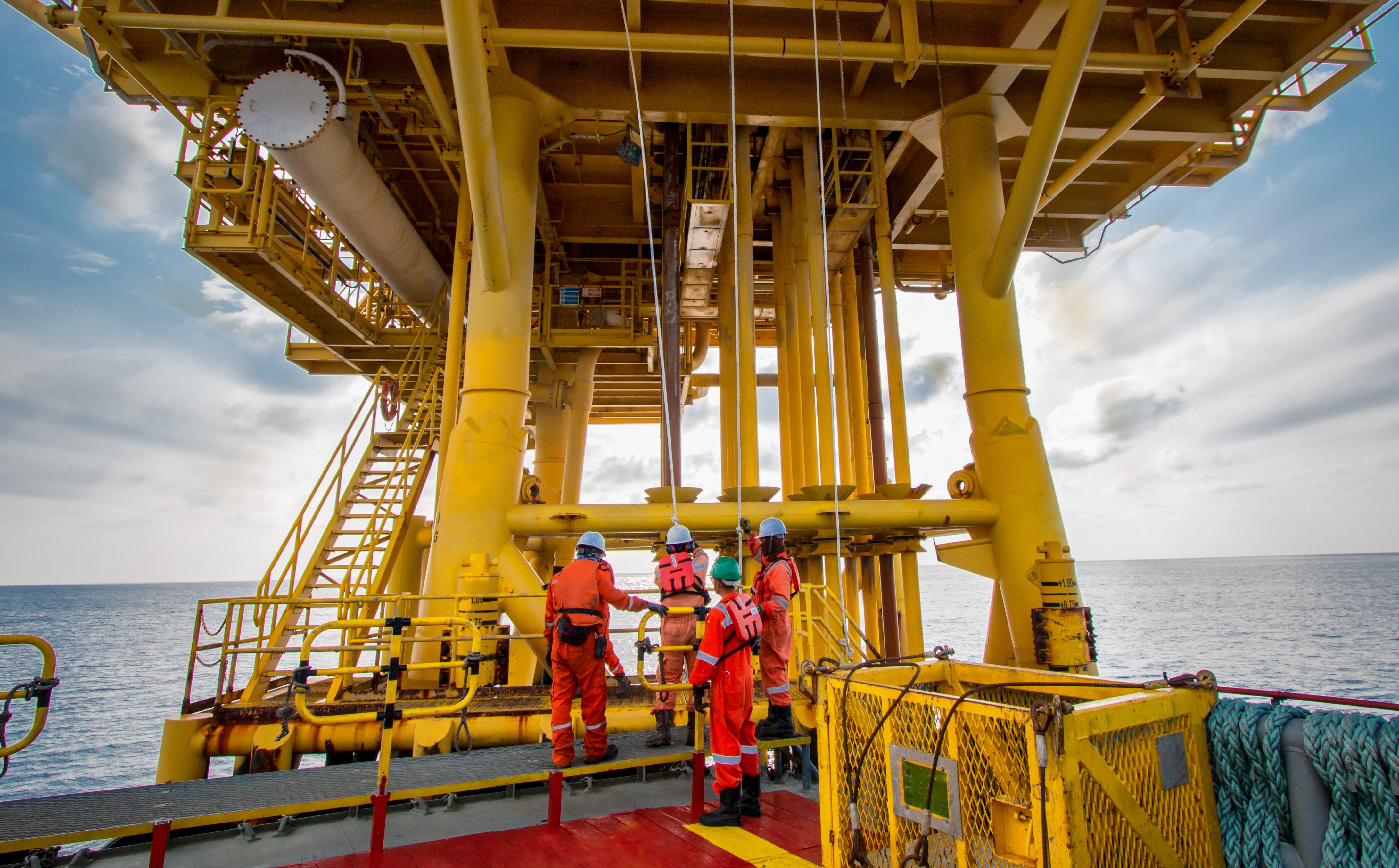 4 workers on offshore oil rig platform  