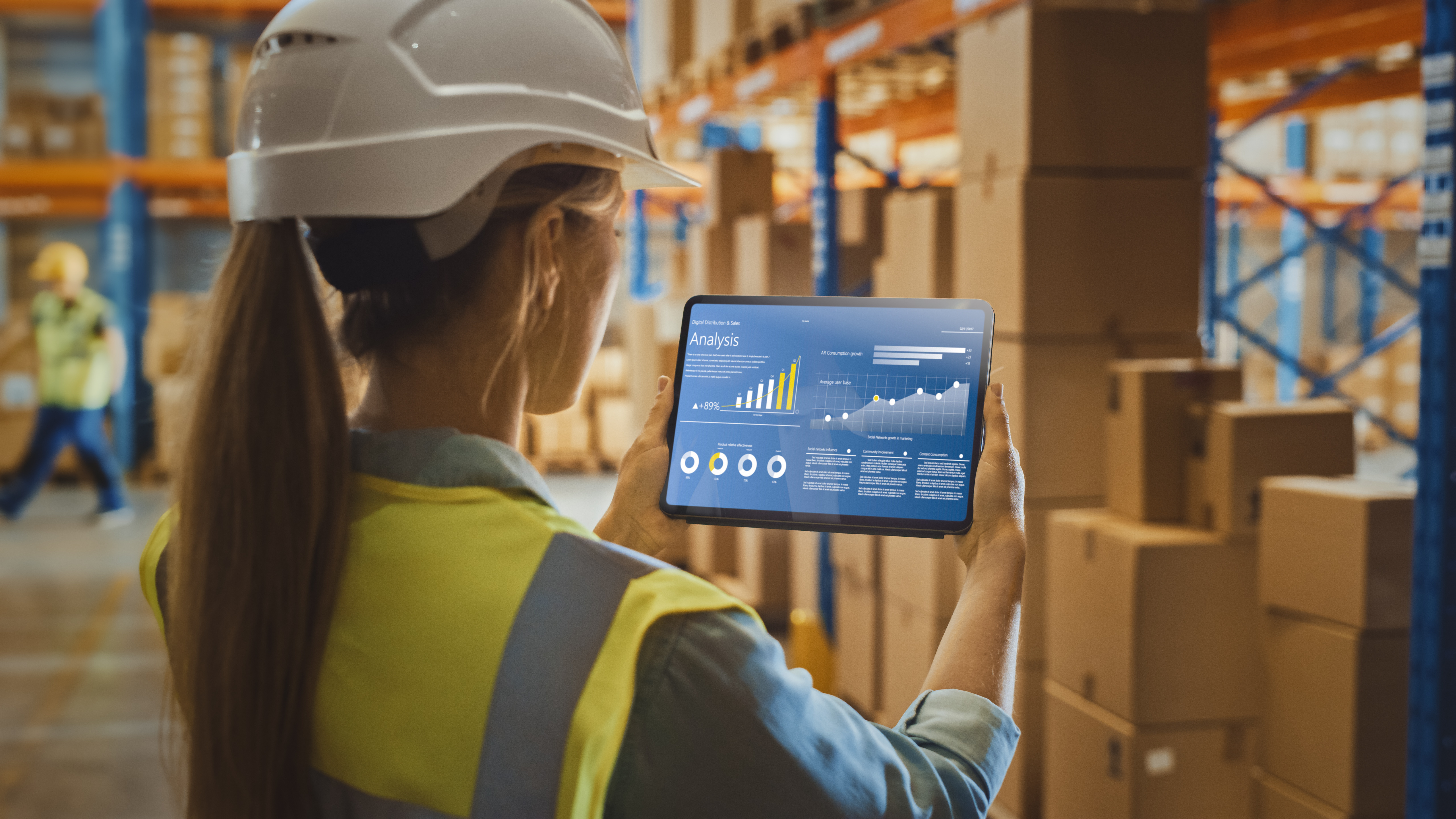 Female warehouse worker reviewing analytics on a tablet