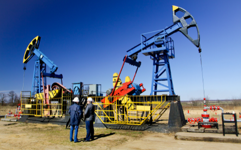 Two technicians standing by an oil rig