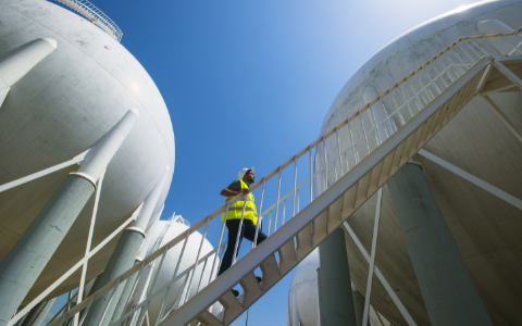 Technician walking up steps of large storage tank